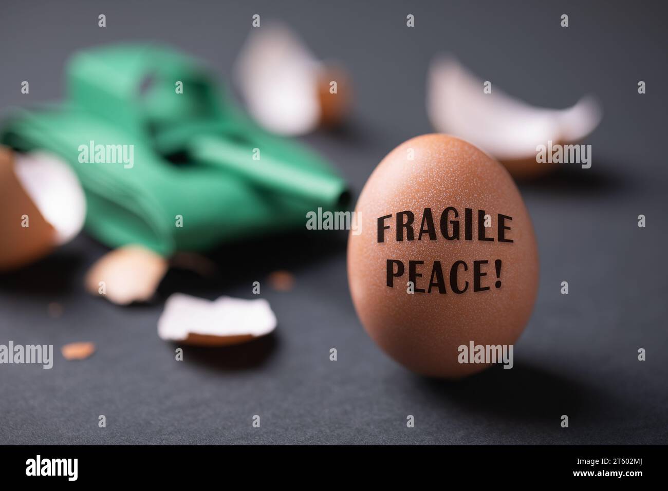 Serbatoio di carta giocattolo, uovo rotto e intero su sfondo scuro, concetto sul tema dell'instabilità nel mondo Foto Stock