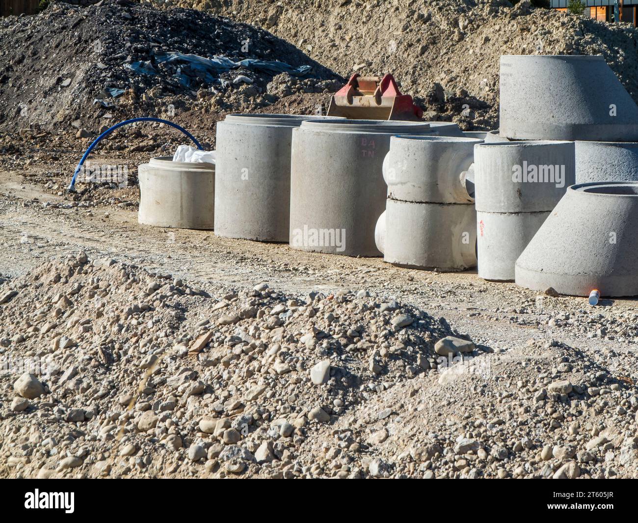 Anelli di cemento per la costruzione di pozzi in un cantiere alla luce del giorno nella somme in Baviera. Foto Stock