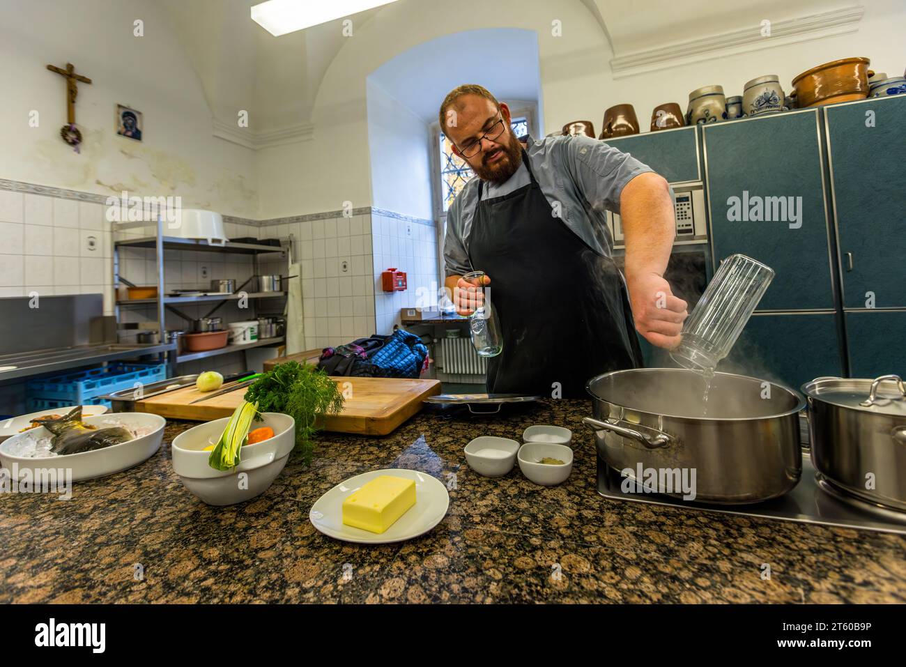 Lo chef Benjamin Standfest prepara il brodo di aceto e acqua, verdure e carpe per il classico piatto di carpa blu. Waldsassen, Germania Foto Stock