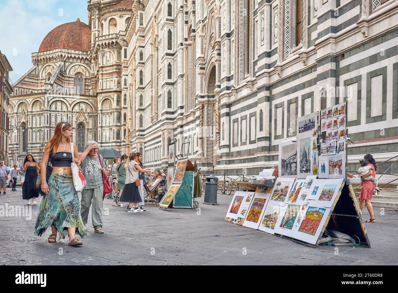 Firenze, Toscana, Italia - Settember16, 2023: Piazza del Duomo a Firenze artisti di strada stazioni con dipinti e turisti che passeggiano, giovani e giovani Foto Stock