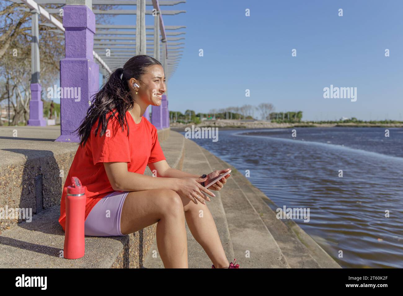 Ragazza in abbigliamento sportivo seduta sulle scale che si prende una pausa. Foto Stock