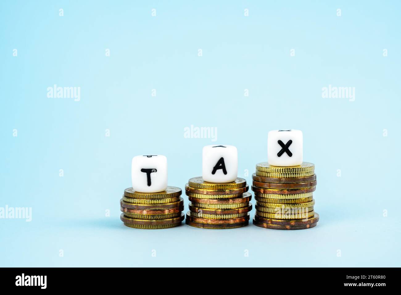 Testo fiscale in cima alla pila di monete Foto Stock