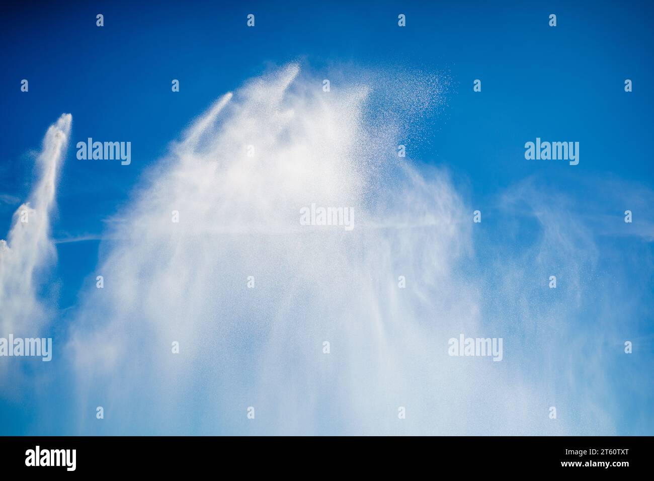 Spruzzi d'acqua a mezz'aria sul cielo blu Foto Stock