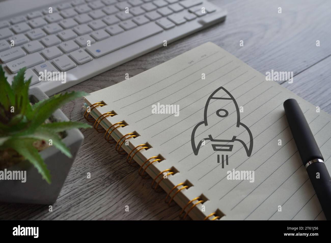 Immagine ravvicinata di un notebook con l'icona di un razzo volante. Concetto di avvio aziendale. Foto Stock