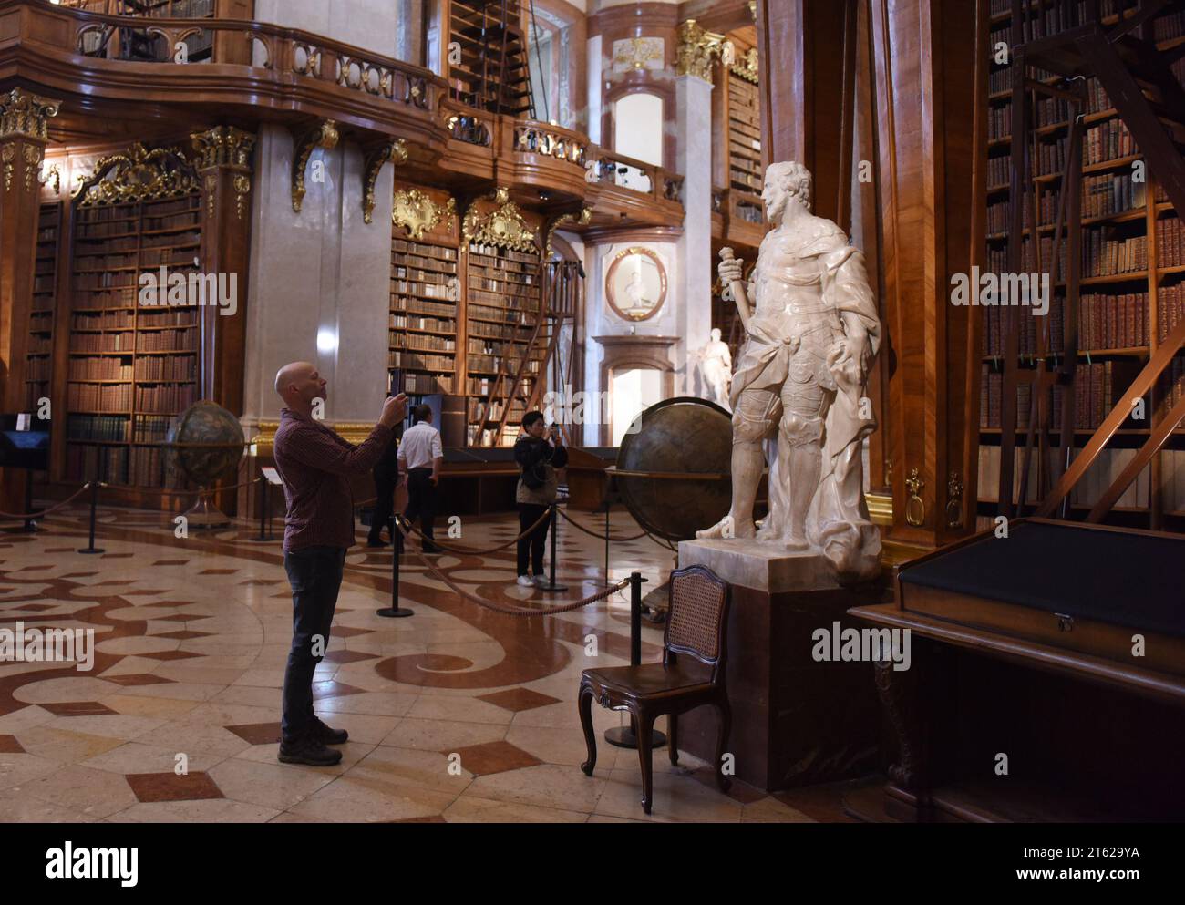 Vienna, Austria. 7 novembre 2023. Il 7 novembre 2023, la gente visita il Palazzo di Stato della Biblioteca Nazionale austriaca a Vienna, Austria. La State Hall della biblioteca è un tesoro di architettura barocca, con bellissimi murales in tutta la sala. Credito: He Canling/Xinhua/Alamy Live News Foto Stock