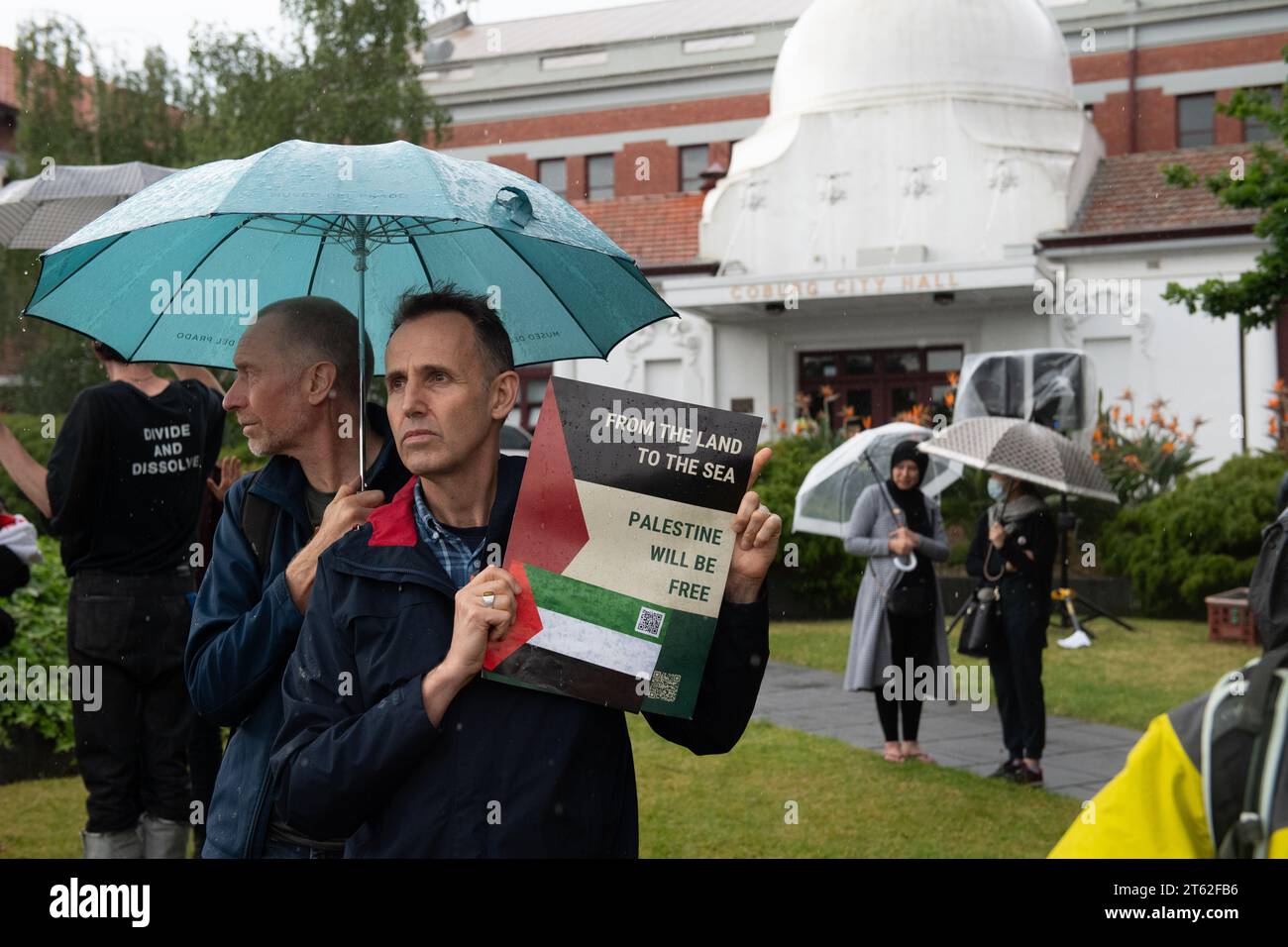 8 novembre 2023, Melbourne, Australia. Un attivista pro-palestinese tiene un segno sotto la pioggia come parte di una manifestazione fuori dal municipio di Coburgo per sostenere i membri del consiglio Merri-bek che hanno votato con successo una mozione a favore di un cessate il fuoco a Gaza, oltre a fornire aiuti a coloro che vivono nell'area devastata dalla guerra e a cessare qualsiasi contratto del consiglio a sostegno dell'esercito israeliano. Queste mozioni saranno poi trasmesse al governo federale. Crediti: Jay Kogler/Alamy Live News Foto Stock