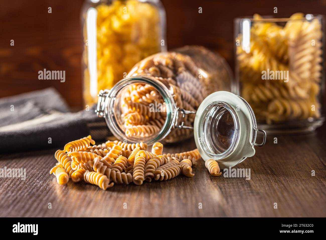 Pasta fusilli cruda a grani interi. Pasta cruda sul tavolo di legno. Foto Stock