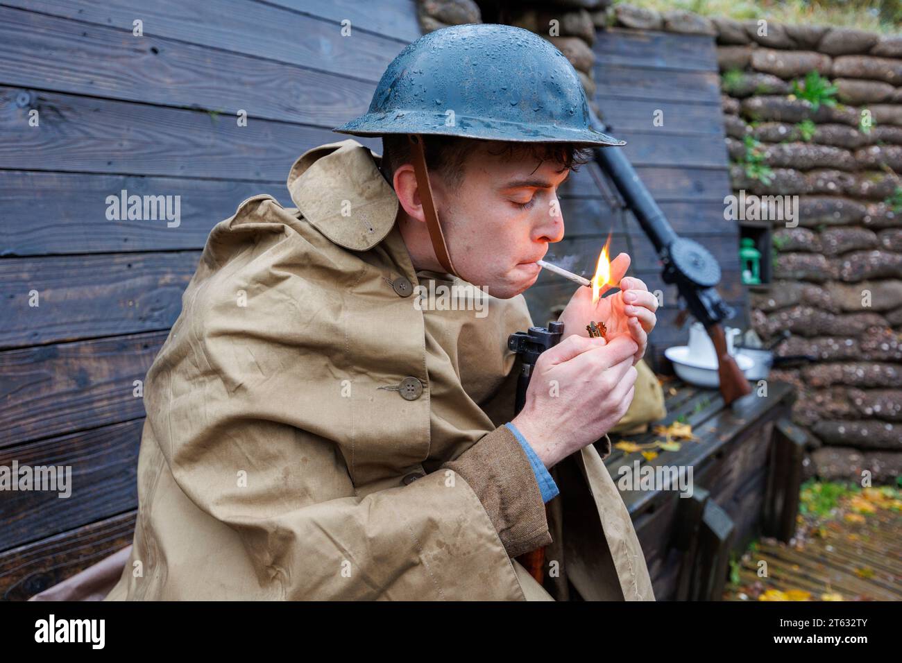 Lo Staffordshire Regiment Museum ha costruito trincee modellate su quelle reali utilizzate durante la guerra mondiale per offrire ai visitatori un'esperienza di com'era la vita per i soldati nelle trincee. Il museo ospita eventi che utilizzano reenattori per creare l'atmosfera e riportare in vita la storia del periodo. Nella foto, Isaac Marlow (27) della truppa di Birmingham Pals accende una sigaretta arrotolata in una delle trincee utilizzando un accendino francese del periodo. Foto Stock