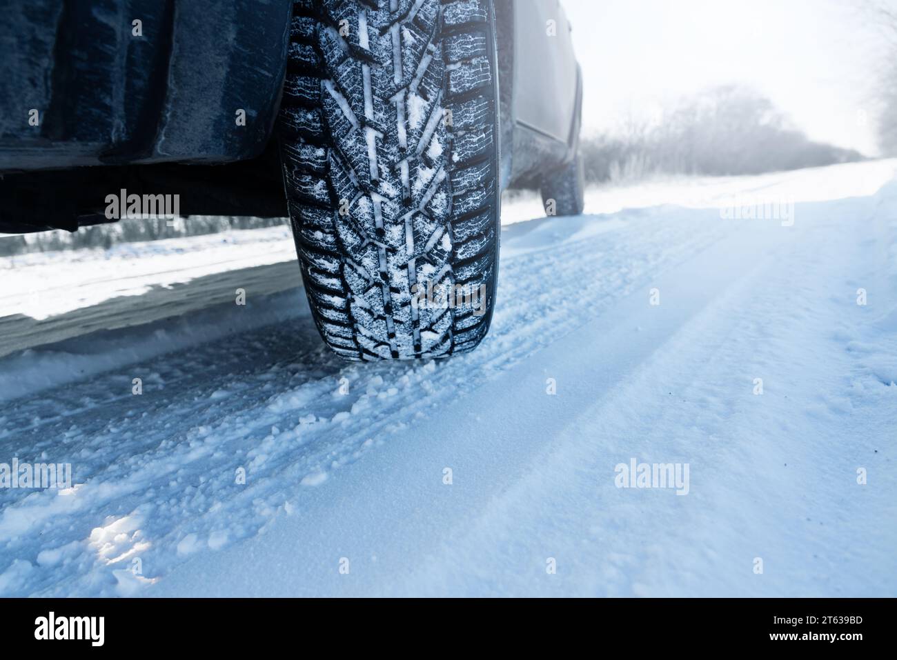 L'auto si trova su una strada invernale ricoperta di neve. Primo piano dello pneumatico invernale. Foto Stock