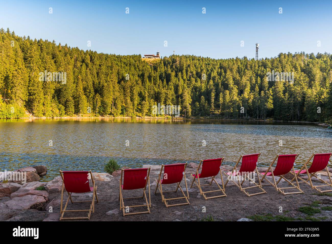 Sedie a sdraio rosse vuote presso il lago Mummelsee con vista sull'Hornisgrinde, il Parco Nazionale della Foresta Nera, Seebach, Baden-Wuerttemberg, Germania Foto Stock