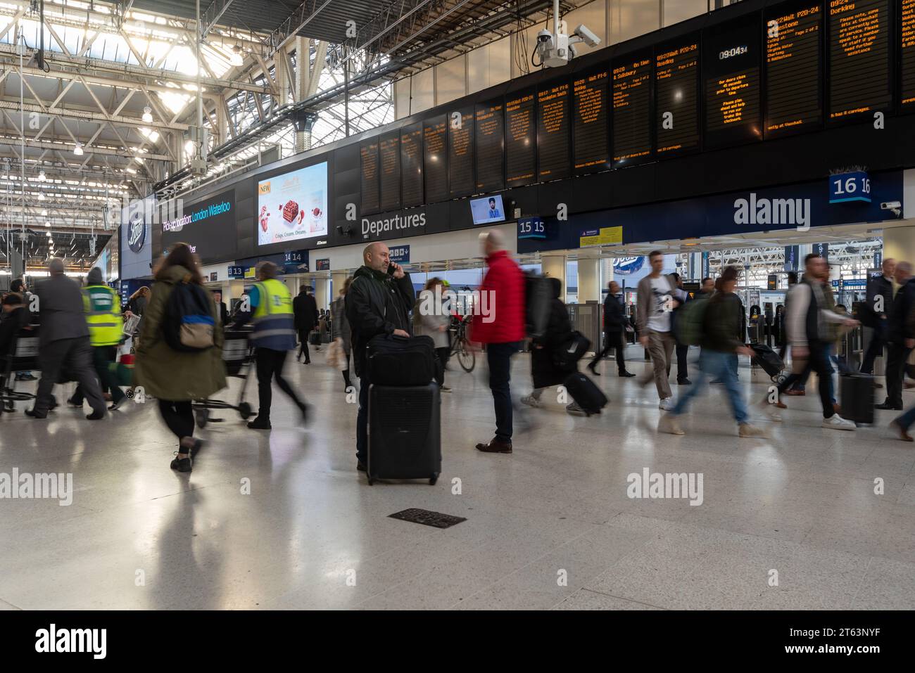 Ora di punta alla stazione ferroviaria di Waterloo a Londra, le persone che viaggiano in tutte le direzioni vengono mostrate rapidamente con una velocità dell'otturatore bassa. Novembre 2023. Foto Stock
