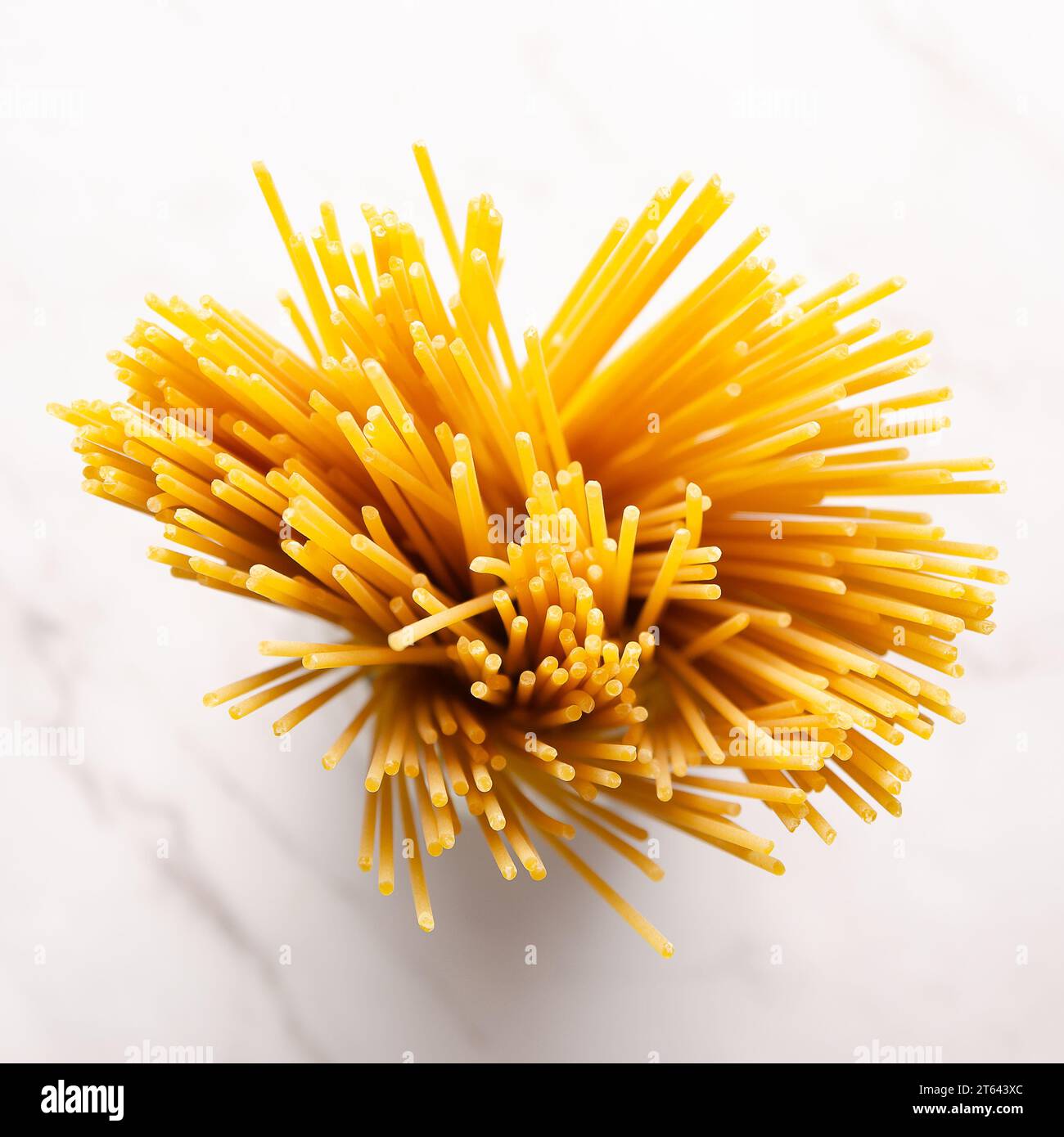 Un mucchio di spaghetti su uno sfondo di marmo bianco. Vista dall'alto. Formato quadrato. Foto Stock