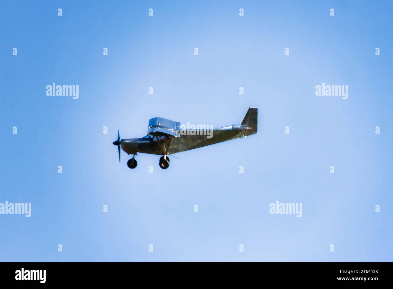 piccolo aereo che vola su un cielo blu, vista laterale con alcune nuvole Foto Stock