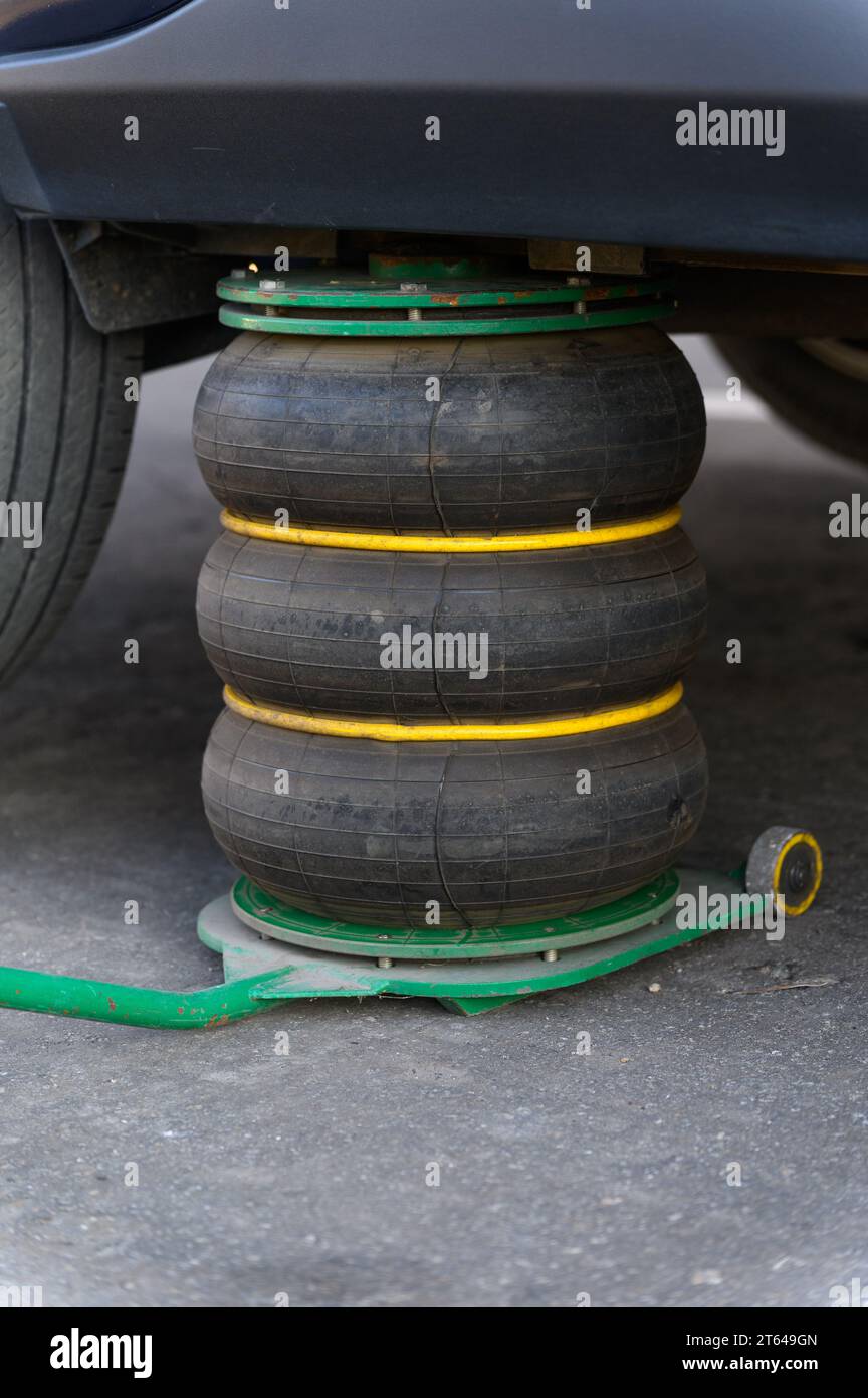 Un martinetto pneumatico sostiene il veicolo durante la sostituzione degli pneumatici. Primo piano. Foto Stock