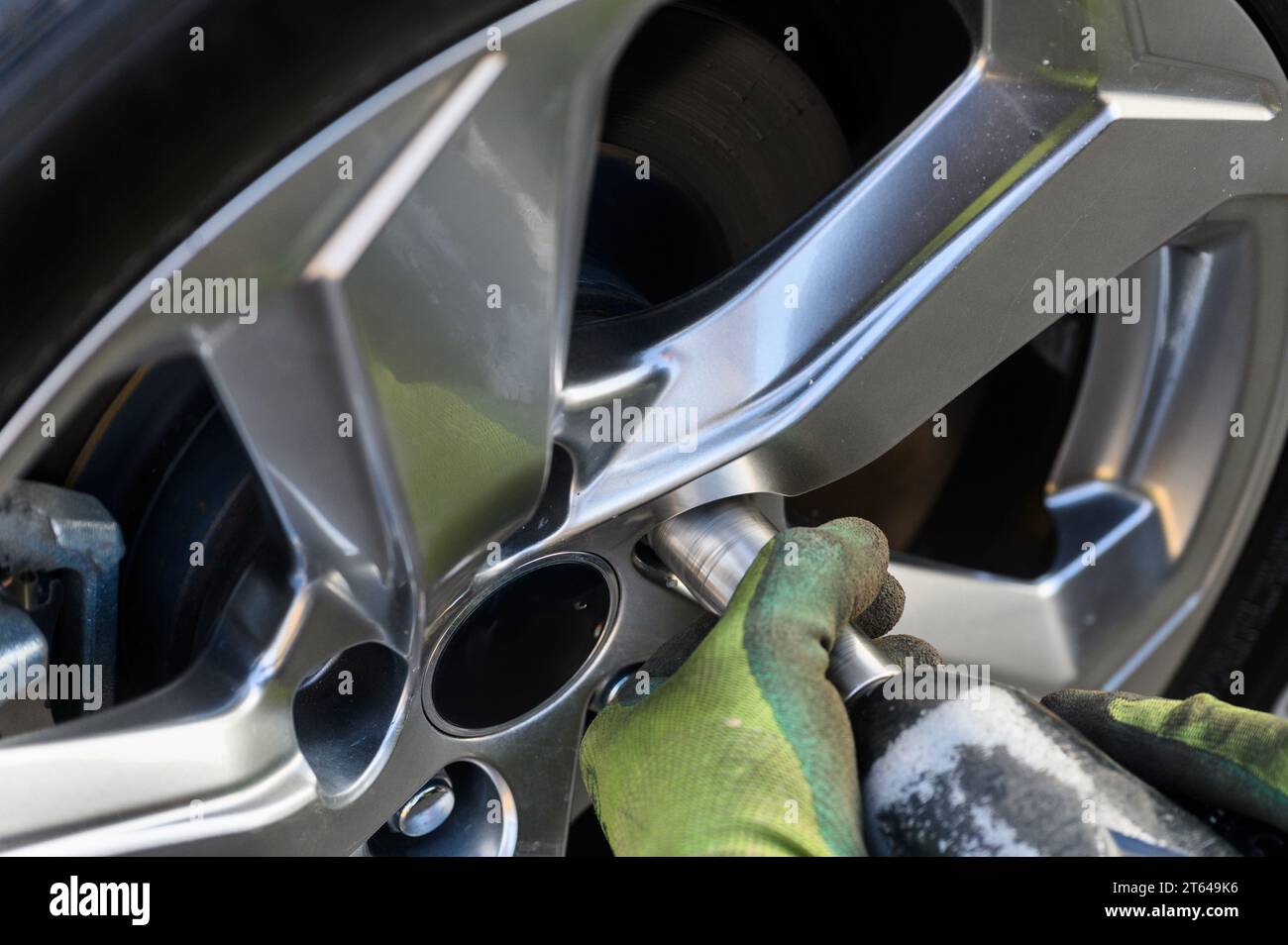Meccanico di auto che cambia pneumatici in un'auto all'aperto Foto Stock