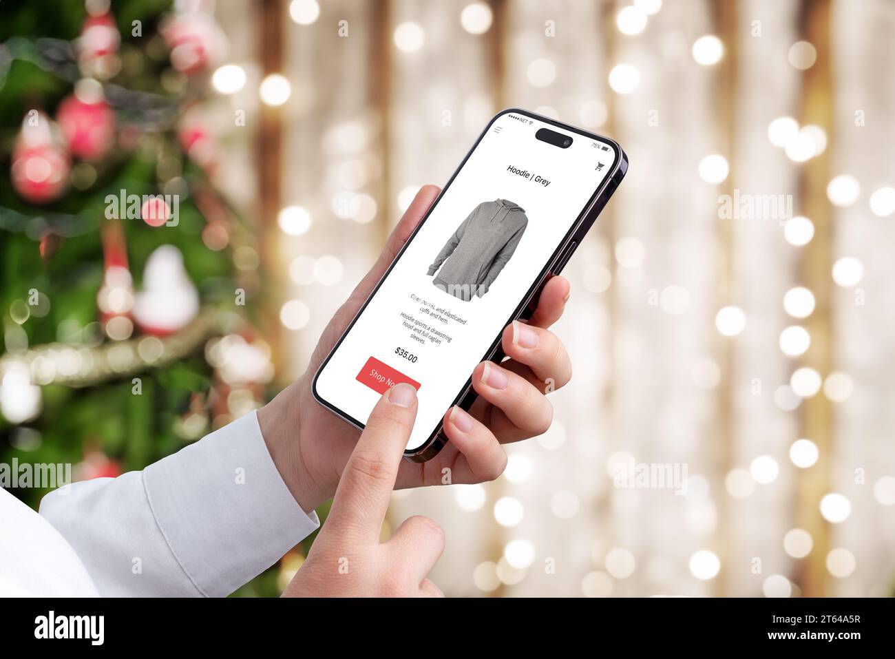 Shopping natalizio tramite cellulare sul moderno sito di e-commerce. Luci dell'albero di Natale e bokeh sullo sfondo Foto Stock