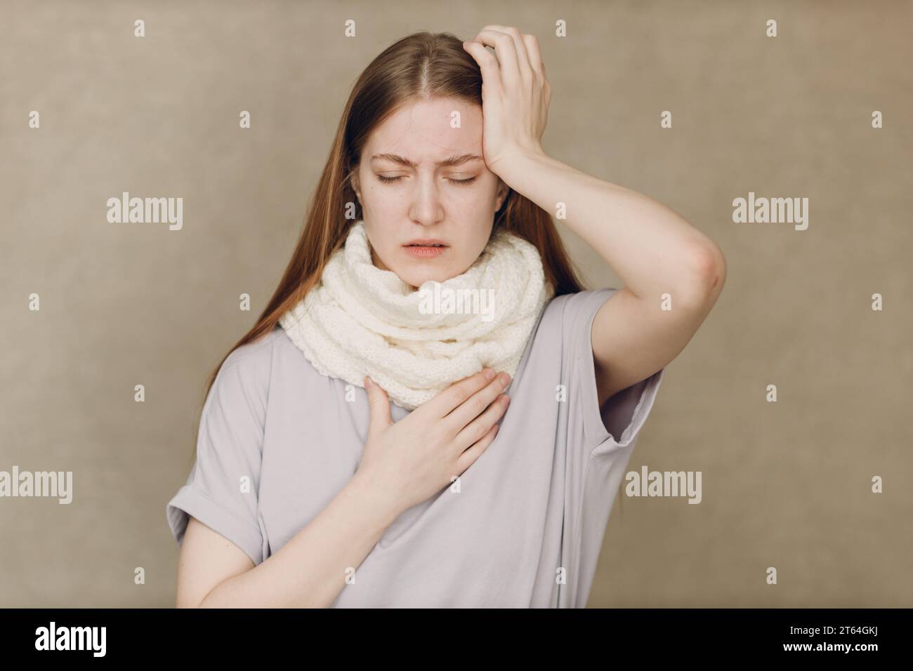 Giovane donna che indossa sciarpa tiene testa influenza catarrh malato malattia trattamento freddo Foto Stock