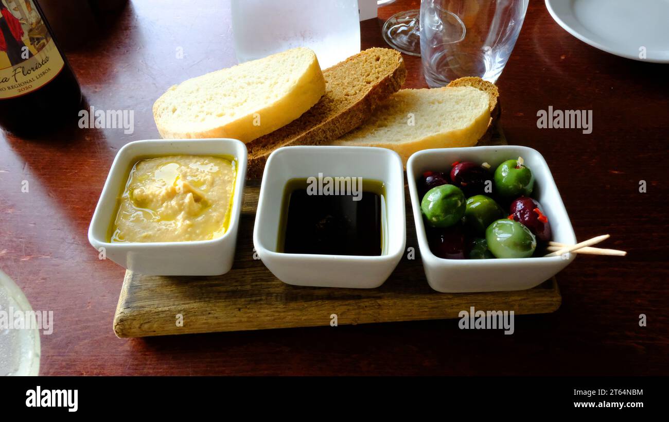 Humus, aceto basalmico, olive servite come antipasto prima di cena - John Gollop Foto Stock