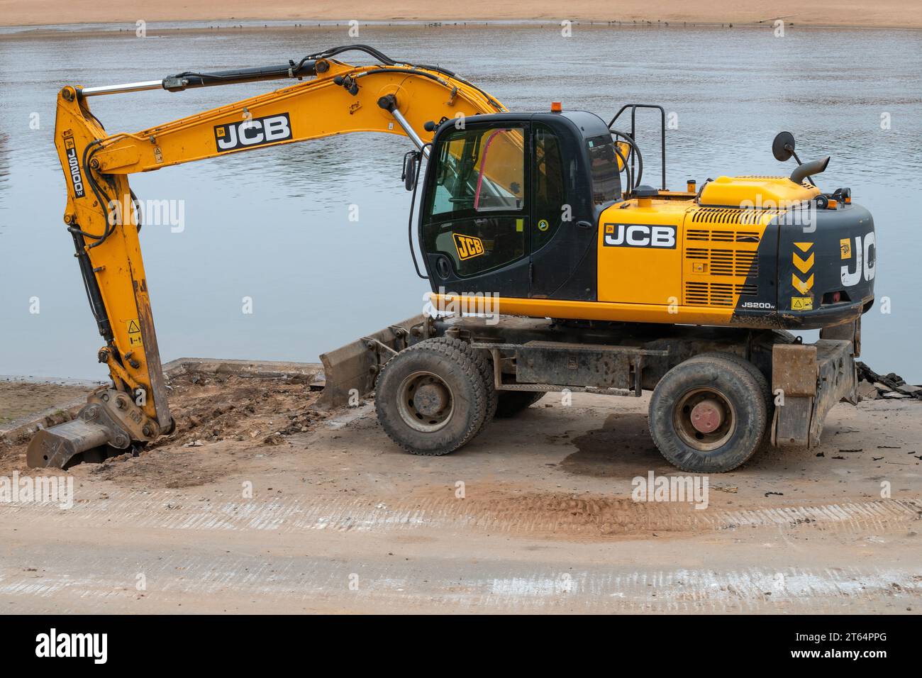 VELIKY NOVGOROD, RUSSIA - 30 SETTEMBRE 2023: Escavatore gommato JCB JS200W sulla riva del fiume Volkhov. Riparazione dell'argine della città Foto Stock