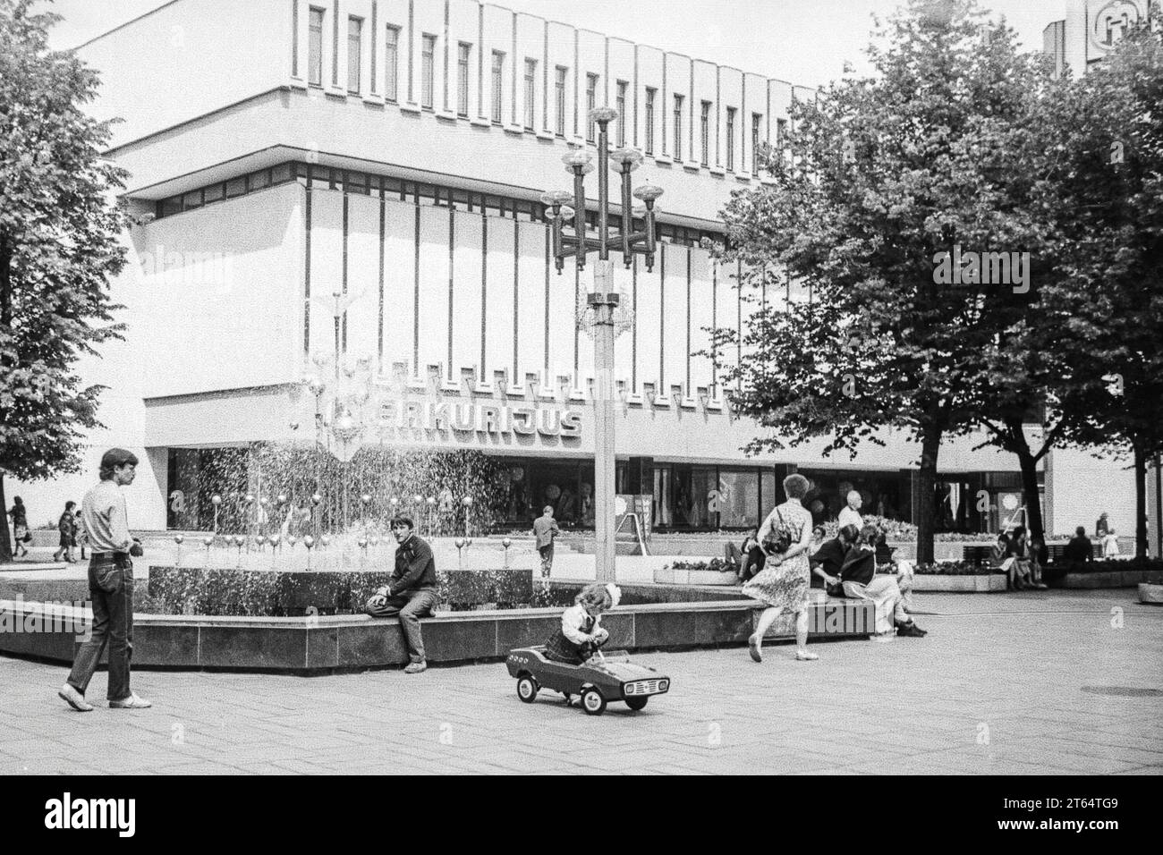 Kaunas, URSS - luglio 1984: Fontana e negozio Merkurijus ormai defunto a Laisves Aleja, Lituania. Scansione di pellicole in bianco e nero da 35 mm Foto Stock
