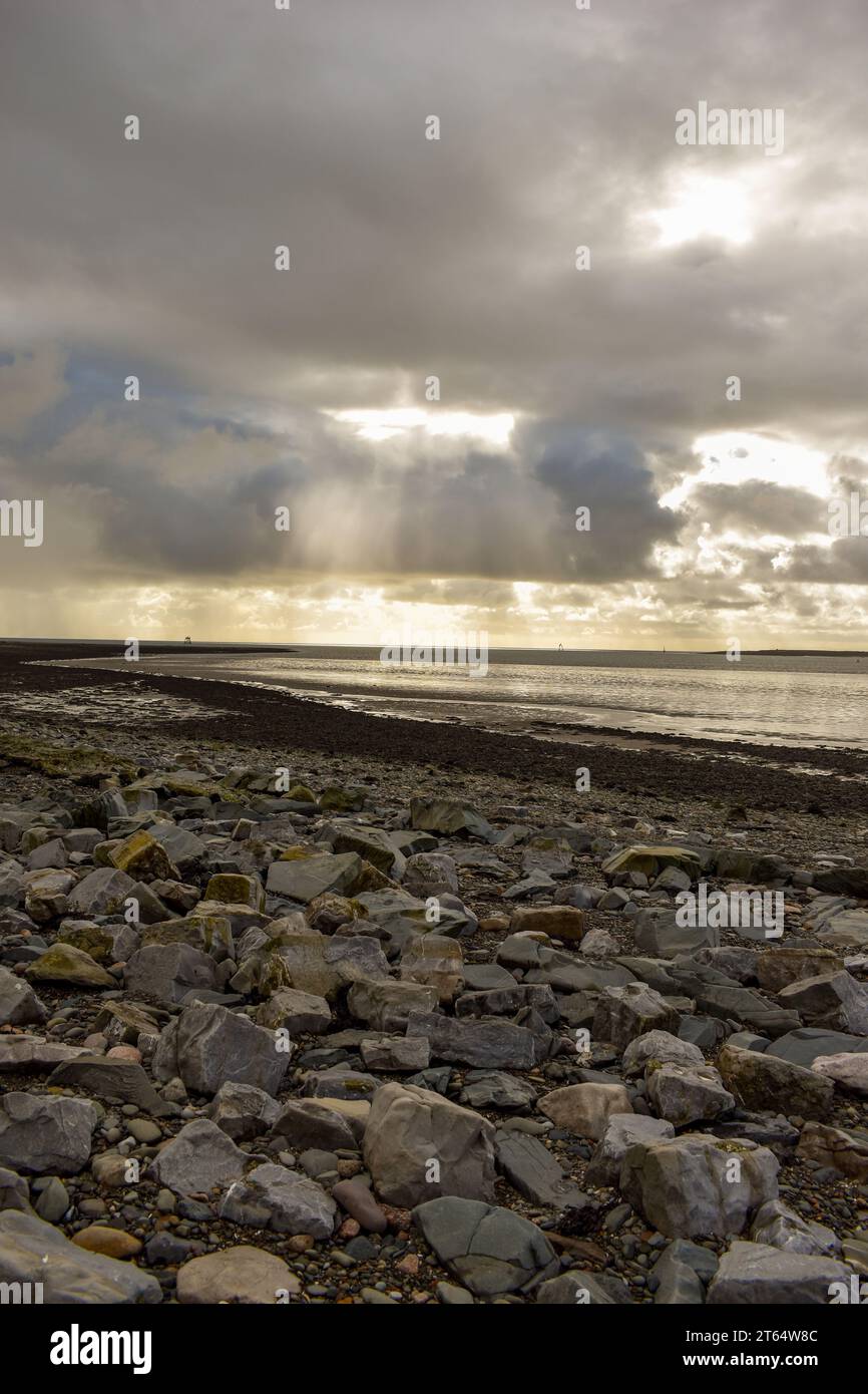 Una costa rocciosa con la bassa marea in una giornata nuvolosa in Cumbria. Foto Stock