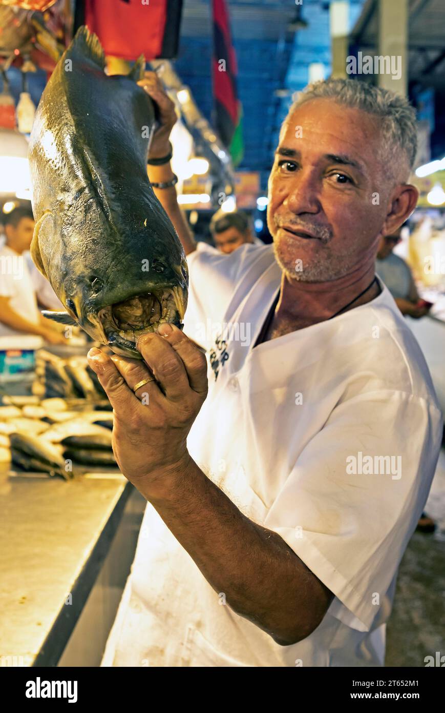 Uomo brasiliano che mostra i grandi denti di un pacu nero o macina tetra o tambaqui, Adolpho Lisboa Municipal Market, Manaus, Stato di Amazonas Foto Stock