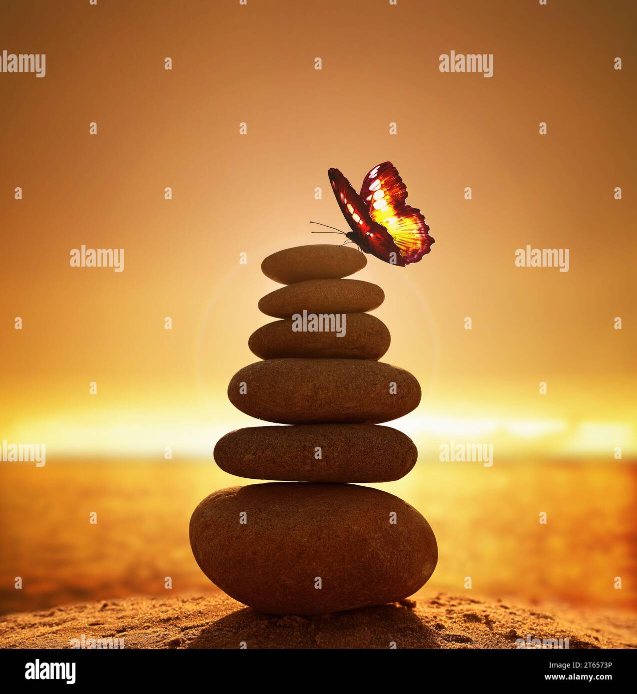 Silhouette a piramide di ciottoli bilanciata sulla spiaggia al tramonto. Mare sullo sfondo. Pietre Zen sulla spiaggia di mare, meditazione, spa, armonia, calma, bal Foto Stock