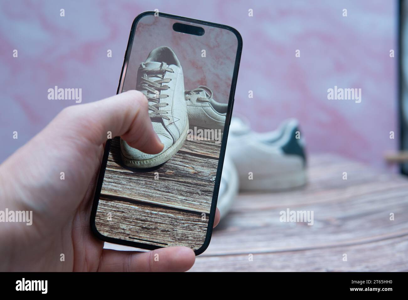 Scattare foto di sneakers di seconda mano alla moda con il telefono. Vendere vestiti online Foto Stock