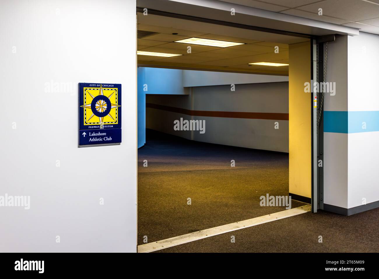 Un cartello ufficiale del "Sistema Pedway della Città di Chicago", che porta il simbolo della stella della bandiera della città, indica la strada per il "Lakeshore Athletic Club", Illinois, Stati Uniti. La rete Pedway è in crescita a Chicago dal 1951, fornendo ai pedoni l'accesso alle importanti destinazioni del centro città, specialmente con il maltempo. Foto Stock