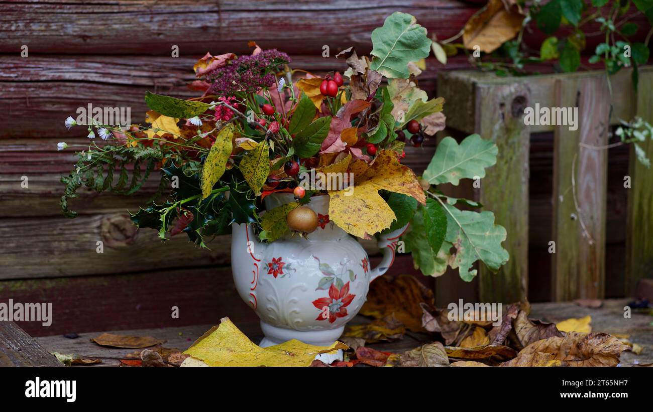 Bouquet di foglie autunnali colorate su una panchina di legno. Foto Stock