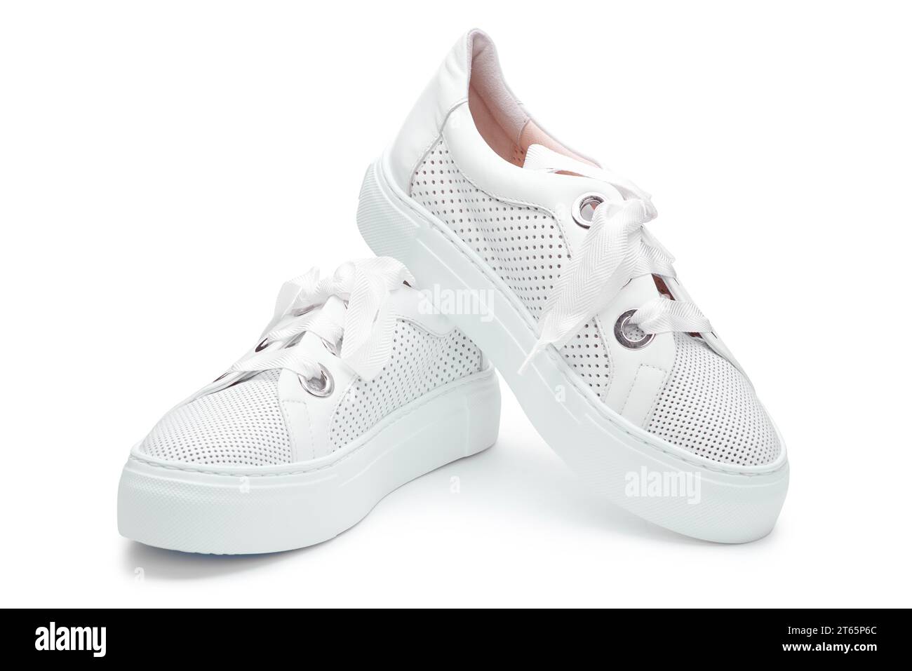 Vista ravvicinata delle sneakers bianche femminili in pelle traforata con spessi lacci isolati su sfondo bianco. Calzature femminili casual ed eleganti. Minimo Foto Stock