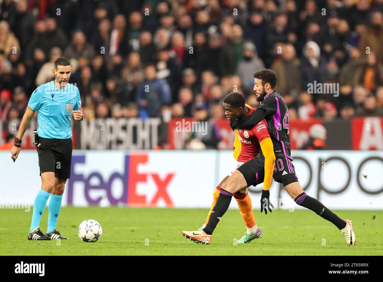 Monaco, Germania. 8 novembre 2023. L'attaccante del Galatasaray Wilfried Zaha (14) è stato placcato dal difensore del Bayern Monaco Noussair Mazraoui (40) durante la partita Bayern Monaco FC contro Galatasaray A.S. FC UEFA Champions League Group A all'Allianz Arena di Monaco, Germania l'8 novembre 2023 Credit: Every Second Media/Alamy Live News Foto Stock