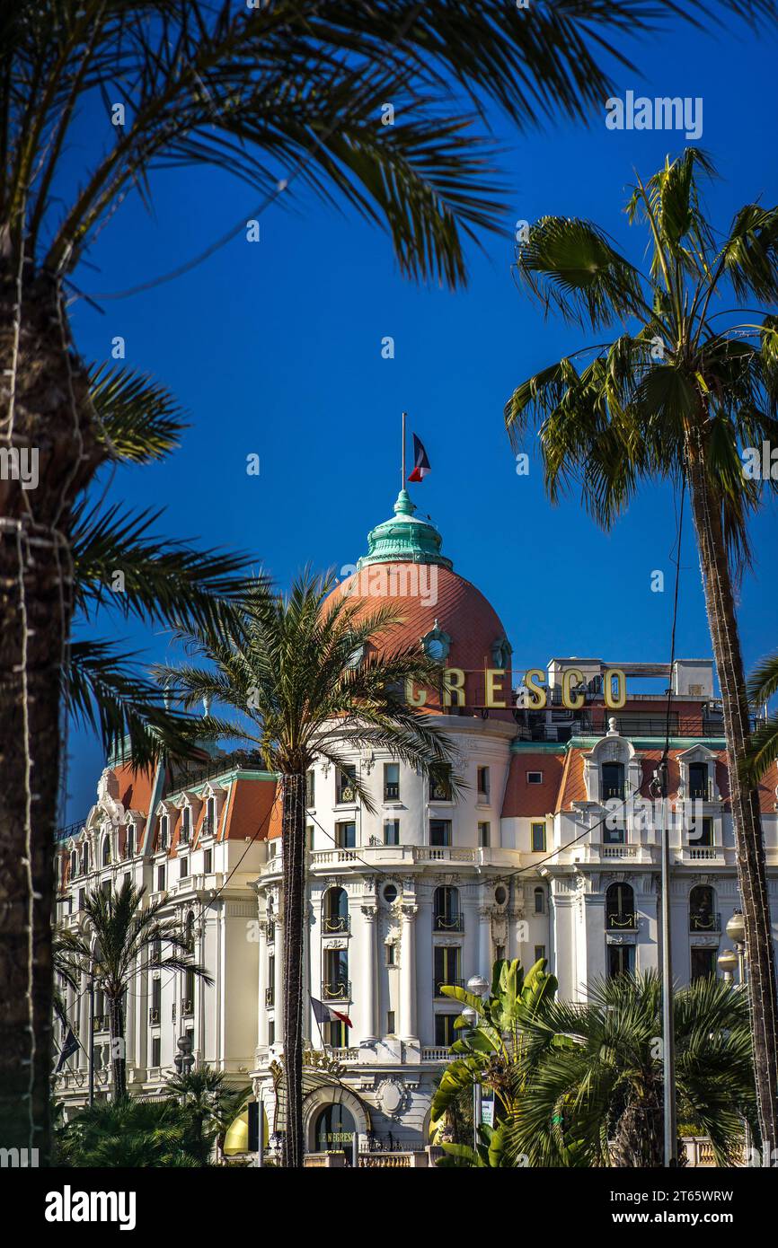 Nizza, Francia - 14 febbraio 2023: Vista sulla strada del famoso Hotel le Negresco di Nizza, incorniciato da palme Foto Stock