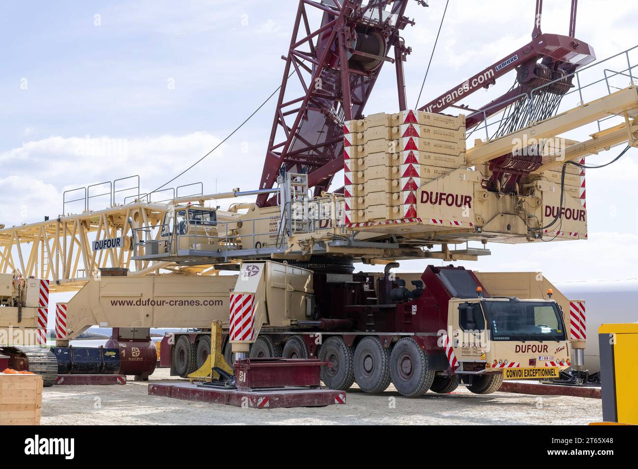 Nancy, Francia - Vista su una gru Beige e Borgogna lattice boom Liebherr LG 1750 nel cantiere di un parco eolico. Foto Stock