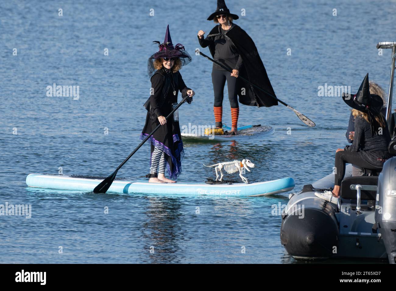 Smiling paddleboard Witch ha un cane scheletro che decora la sua tavola nel 2023 Ventura Harbor Wiches Paddle Out il 27 ottobre. Foto Stock