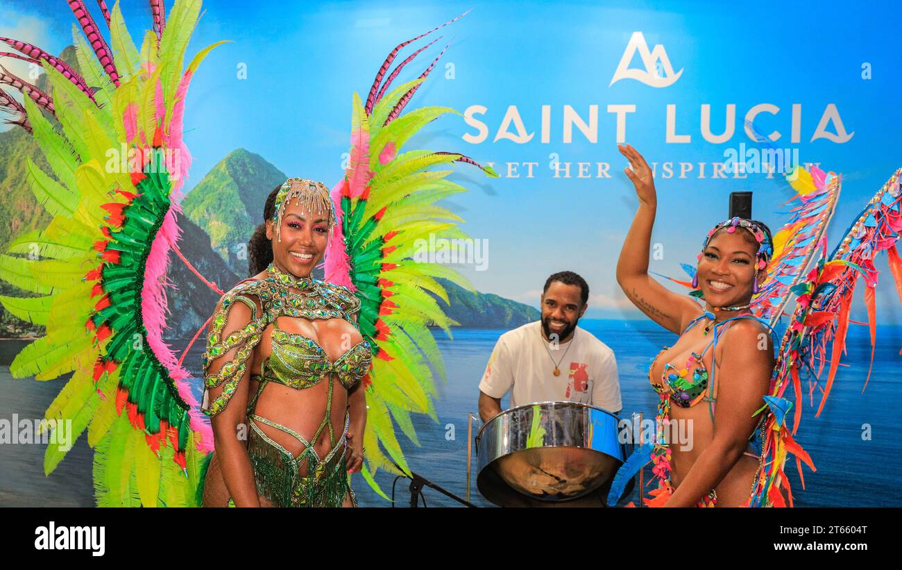 Londra, Regno Unito. 8 novembre 2023. I ballerini del carnevale caraibico portano l'atmosfera allo stand di Saint Lucia, dove vengono servite anche delle bevande. Come ogni anno, nelle ultime due ore dell'ultimo giorno del World Travel Market all'Excel di Londra, molti stand country e stand per mostre di viaggi organizzano riunioni informali e feste di chiusura per celebrare un tre giorni di successo della fiera, spesso con spettacoli, musica, balli, cibo e bevande locali. Crediti: Imageplotter/Alamy Live News Foto Stock