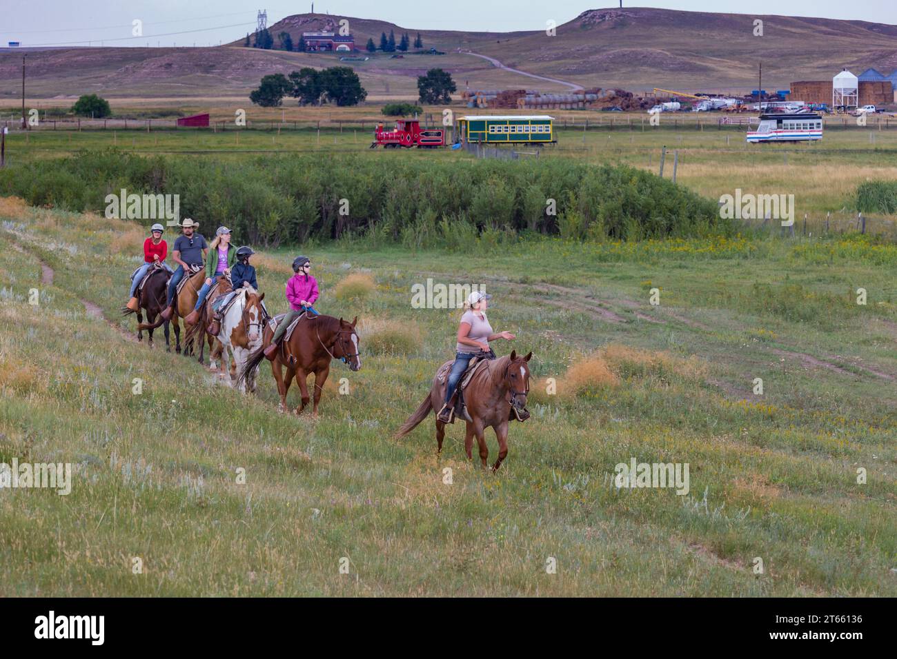 La tua famiglia è guidata da un'escursione a cavallo attraverso i campi del Terry Bison Ranch vicino a Cheyenne, Wyoming Foto Stock