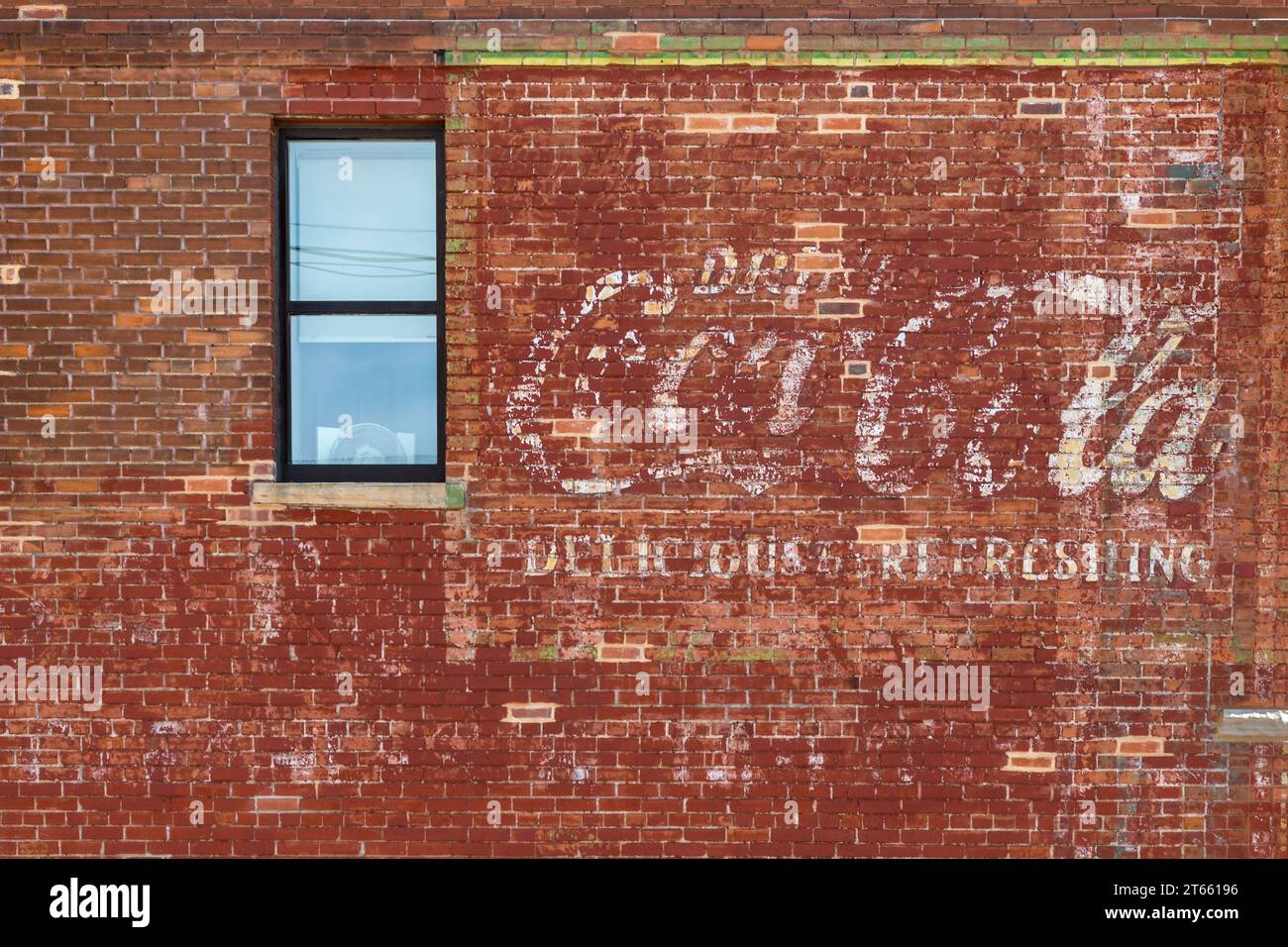 Un cartello pubblicitario della Coca-Cola intemprato e sbiadito dipinto su un muro di mattoni di un edificio storico nel centro di Cheyenne, Wyoming Foto Stock