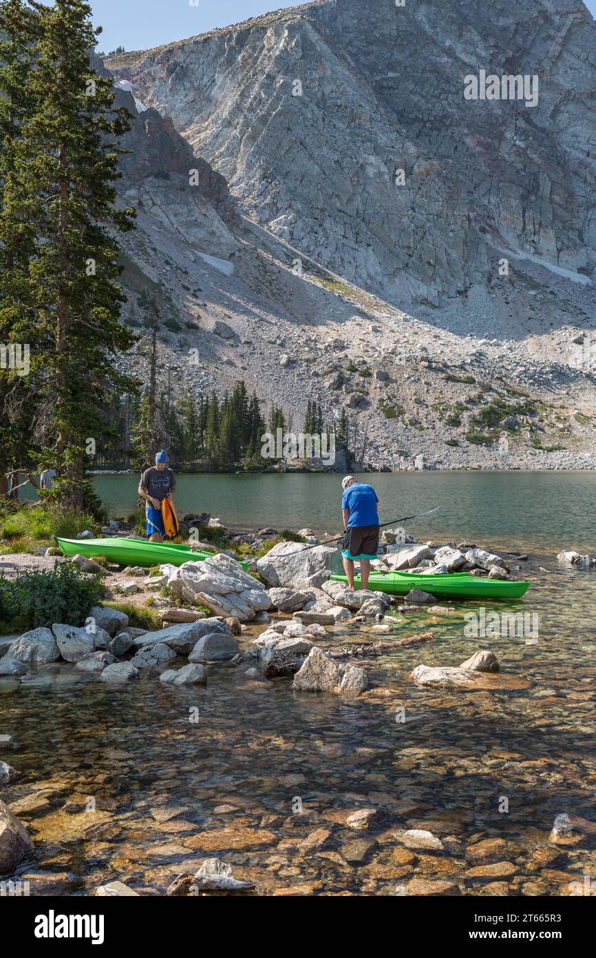 Due giovani si preparano per il kayak lungo la costa rocciosa del lago Marie nella zona della catena montuosa di Medicine Bow National Forest, Wyoming Foto Stock