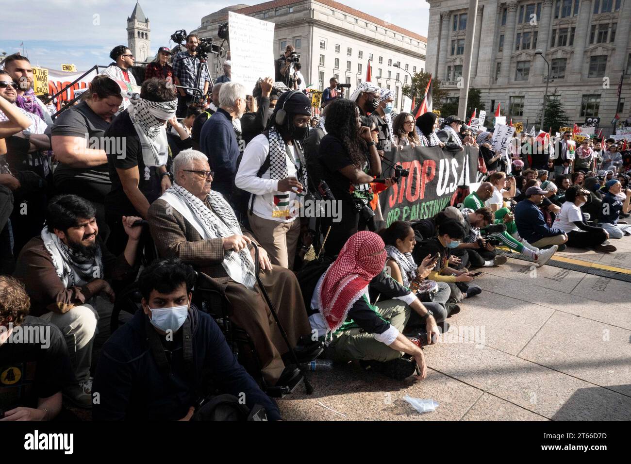 4 novembre 2023, Washington, Distretto di Columbia, Stati Uniti: I membri del pubblico siedono sui gradini della Freedom Plaza, ascoltando intensamente gli oratori durante il raduno pro-palestinese a Washington, DC, il 4 novembre 2023. I partecipanti mostrano striscioni e cartelli, tra cui uno che recita "STOP USAID FOR PALESTINE", che riprendono il sentimento collettivo contro le attuali politiche di aiuti esteri degli Stati Uniti. Il raduno rappresenta una comunità eterogenea, unita dal loro sostegno ai diritti palestinesi e dalla loro opposizione all'escalation dei conflitti. (Immagine di credito: © Douglas Christian/ZUMA Press Wire) EDITORI Foto Stock