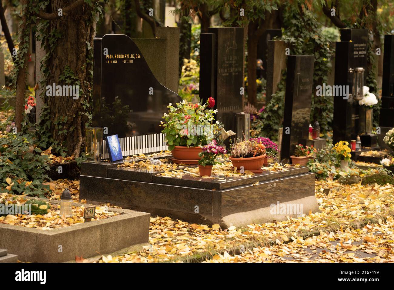 Tomba dello storico letterario ceco, pubblicista e scrittore Radko Pytlík (1928-2022), esperto di Jaroslav Hašek. Tomba a forma di pianoforte, scena autunnale. Foto Stock