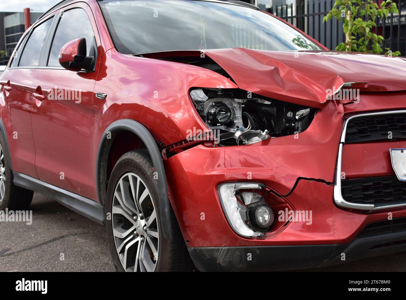 Un'auto che mostra danni ai pannelli e ai fari automatici per la riparazione in caso di incidente frontale. Foto Stock
