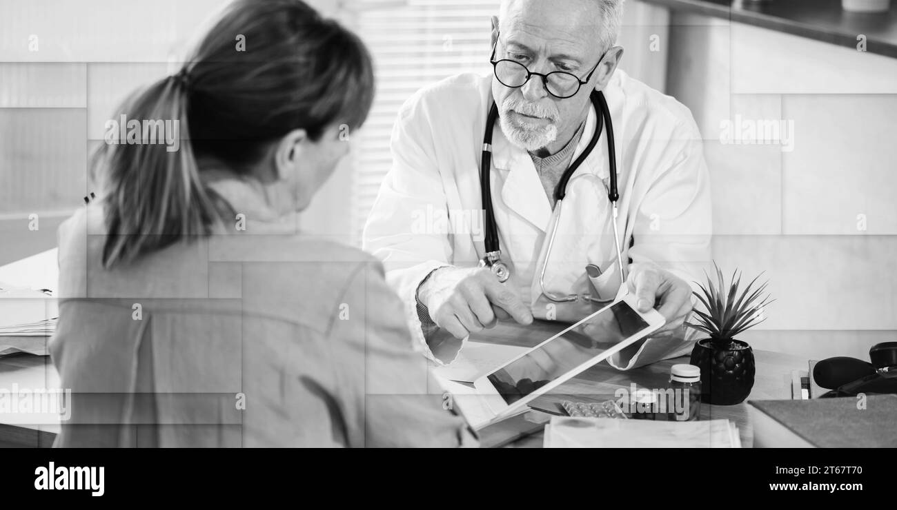 Medico anziano che mostra rapporti su tablet digitale alla sua paziente in studio medico, modello geometrico Foto Stock