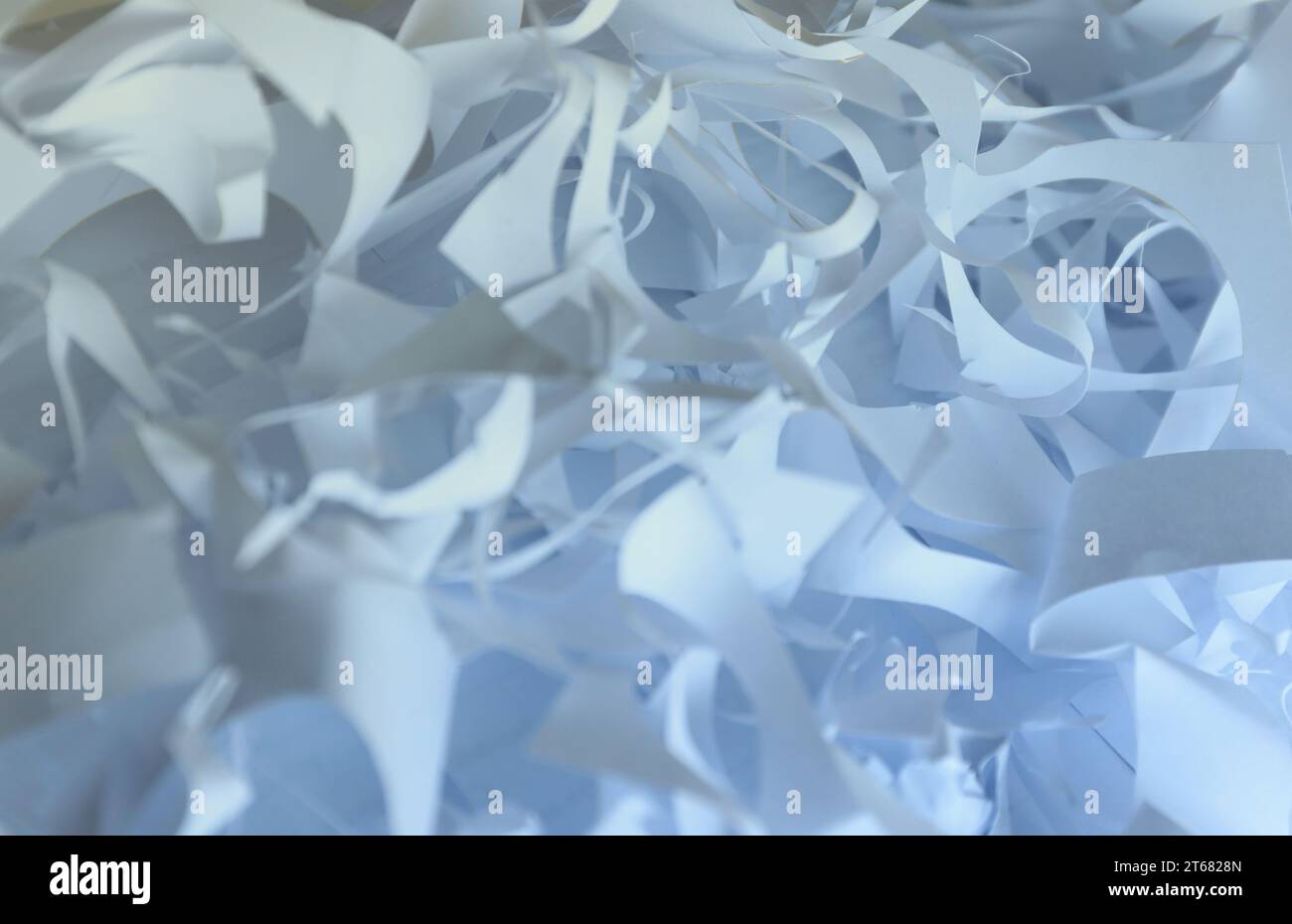 Sfondo con trama di carta triturata, vista dall'alto di molte strisce di carta bianca. Pile di carta tagliata come i corietti per feste o il riempitivo per scatole per la spedizione di articoli fragili Foto Stock