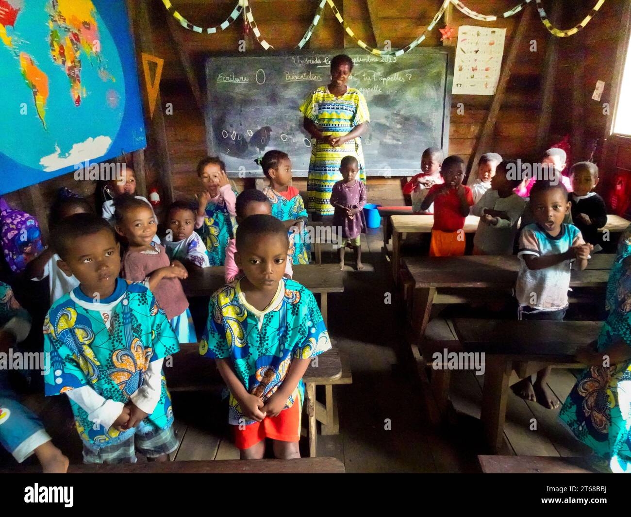 Villaggio di Ambodiforaha, Madagascar settembre 2023 i bambini delle scuole materne voltano le spalle al "maestro" mentre studiano geografia del mondo e del mondo Foto Stock