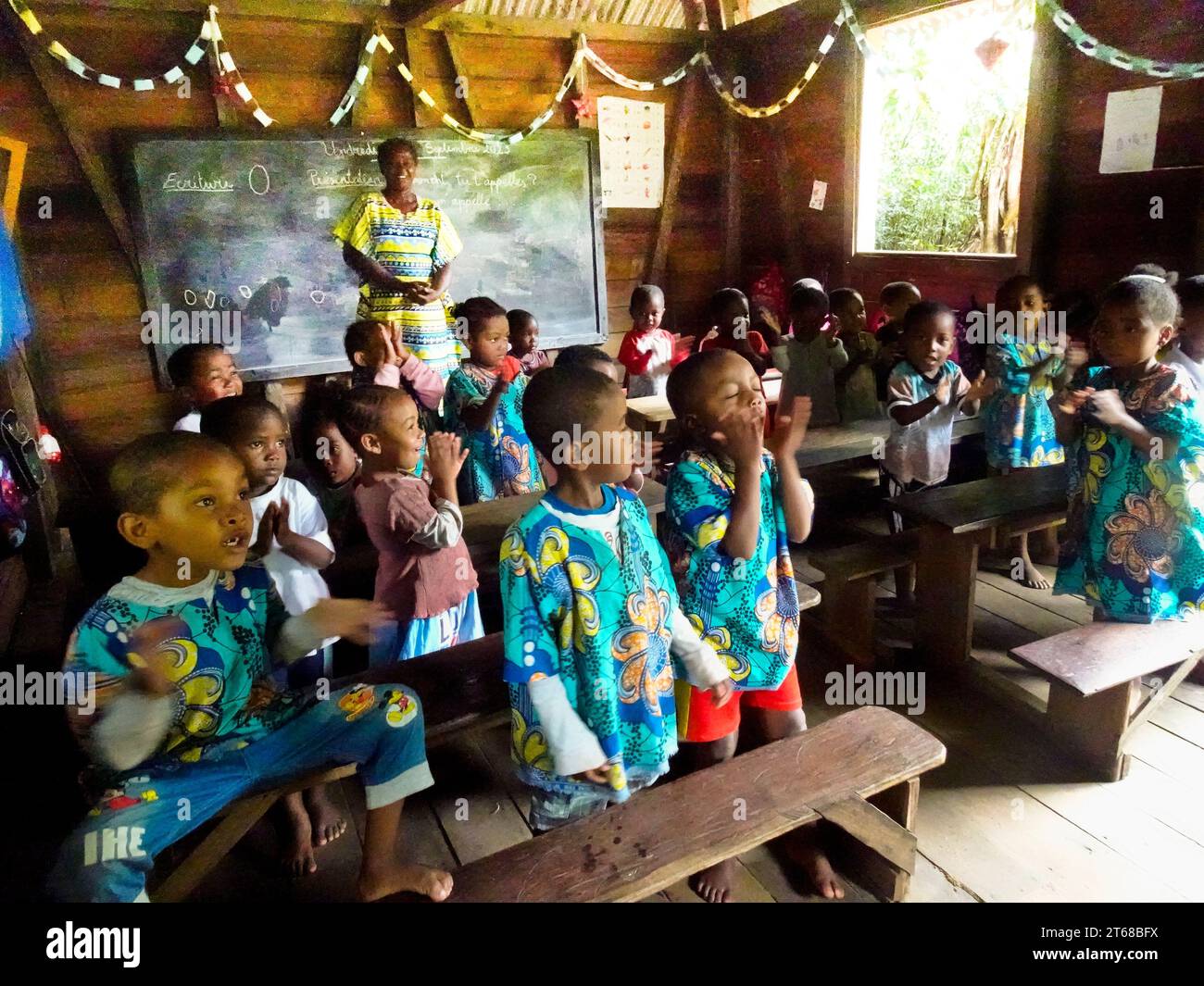 Villaggio di Ambodiforaha, Madagascar settembre 2023 i bambini delle scuole materne voltano le spalle al "maestro" mentre studiano geografia del mondo e del mondo Foto Stock