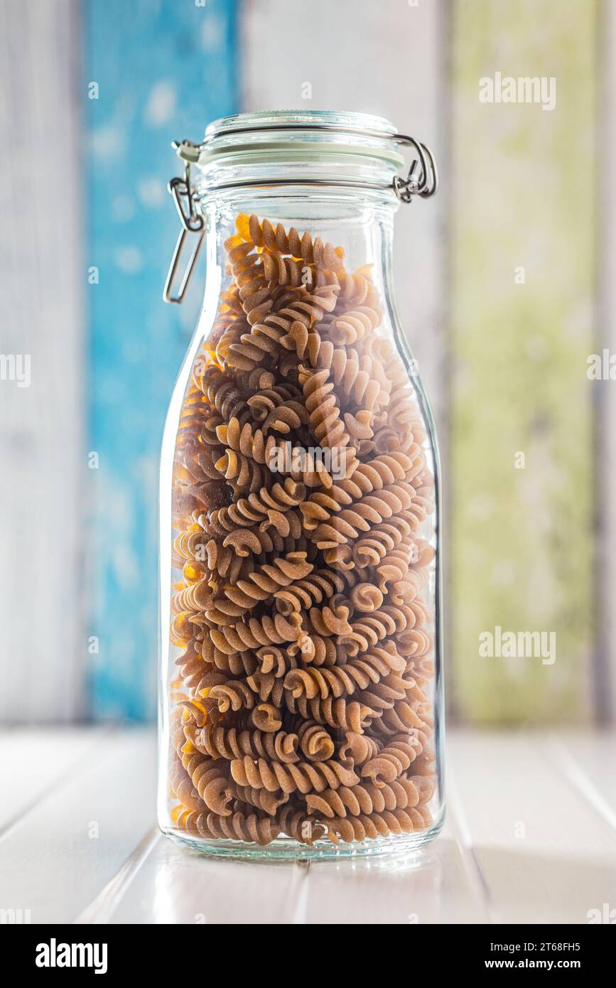 Pasta fusilli cruda a grani interi. Pasta cruda nel vaso. Foto Stock