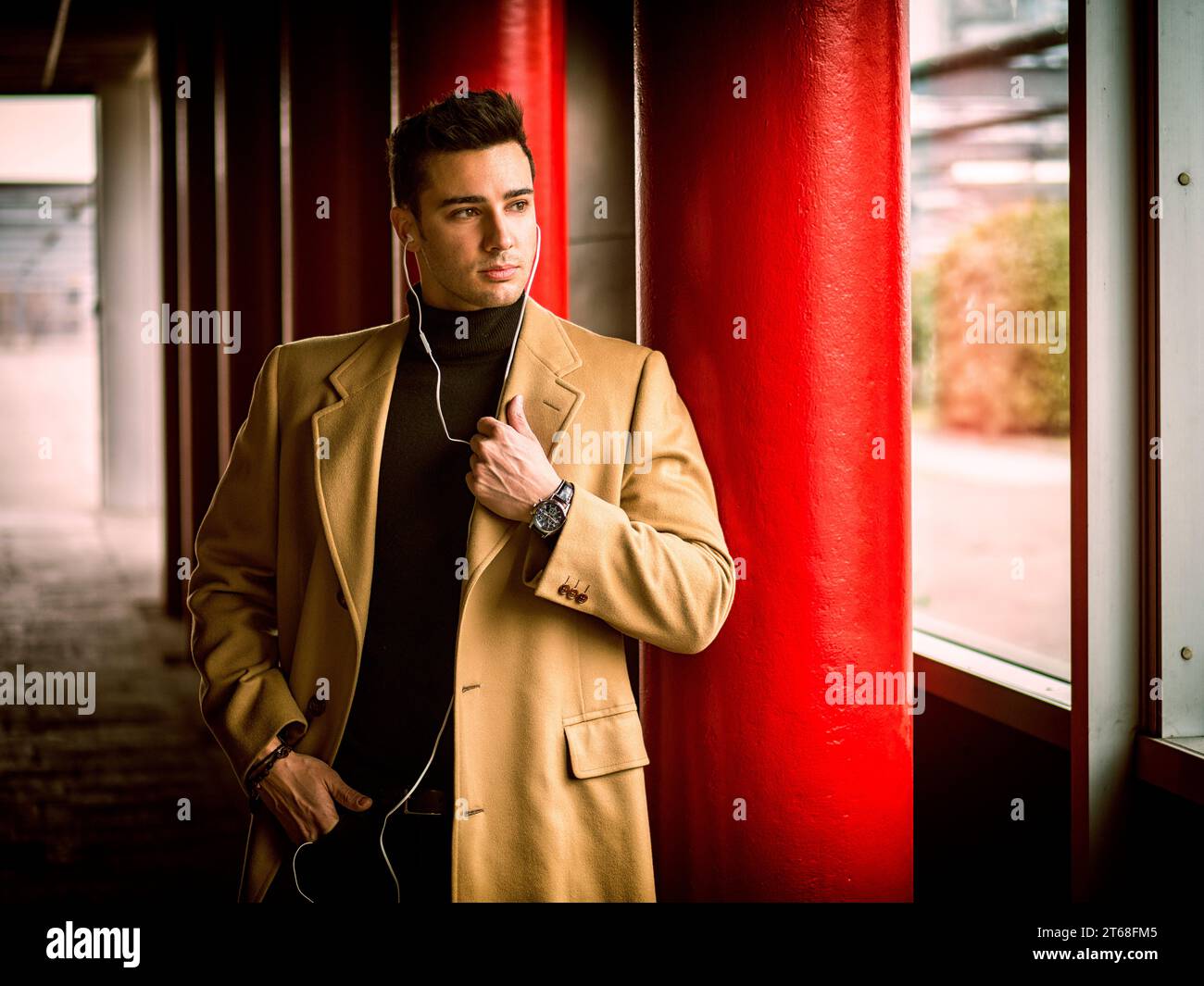 Un uomo con un cappotto abbronzato e una camicia nera. Foto di un uomo alla moda con un cappotto abbronzato e una camicia nera Foto Stock