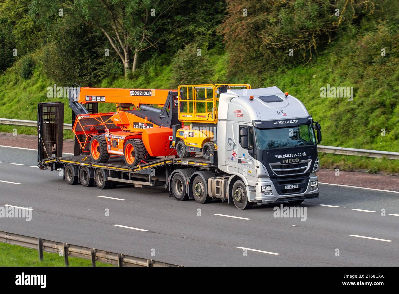GTAccess Ltd, società di noleggio e vendita Powered Access. Iveco Stralis As440s46tx/P S-A Diesel autocarro da 11120 cc e rimorchio Montracon STEP; n in viaggio sull'autostrada M6 a Greater Manchester, Regno Unito Foto Stock