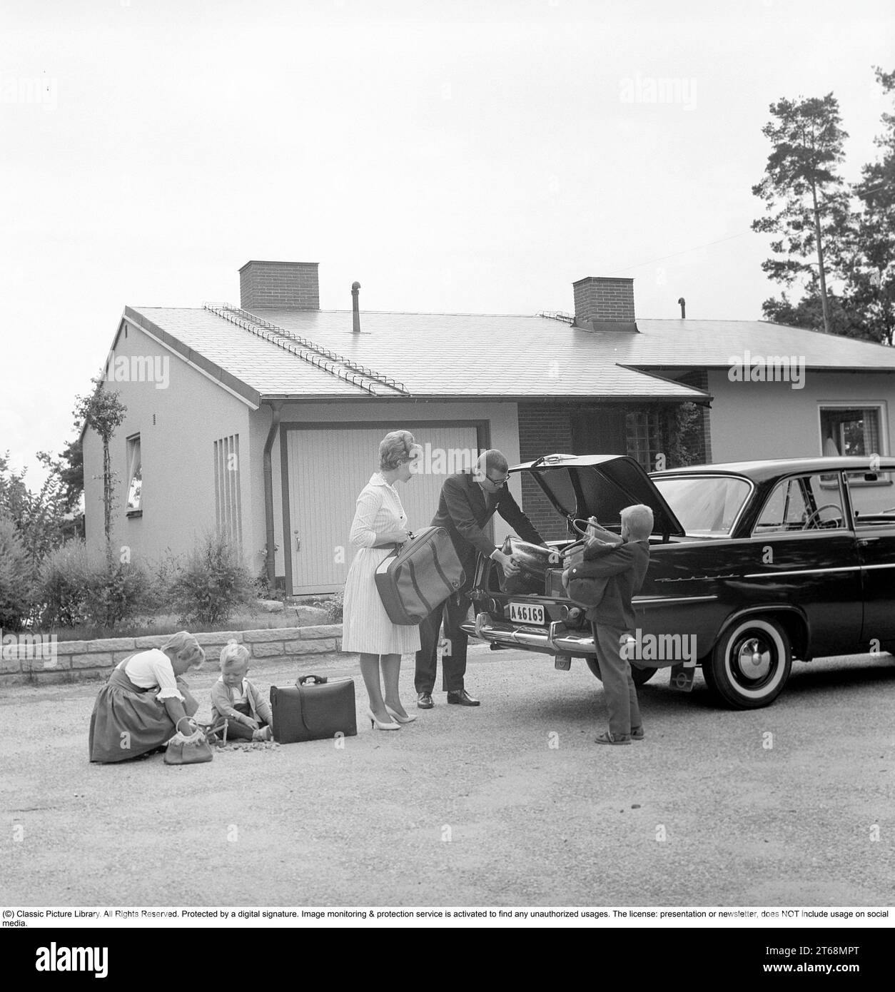 Guidare negli anni '1960 Una famiglia con la loro auto, un Opel Rekord, e la coppia viene vista mettere i loro bagagli e le loro valigie nel bagagliaio. Svezia 1961 Kristoffersson Rif CU75-3 Foto Stock